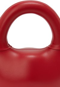Rød lædertaske med et rundt håndtag. Glat tekstur, minimalistisk design og en buet silhuet, der fremhæver slanke linjer.