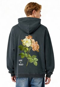 Sötét szürke kapucnis pulóver, pamutb�ól készült, rózsaszín és krémszínű rózsák zöld levelekkel díszítve, fehér "LOVE & ROSES" felirattal.