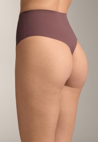 Højtaljede, sømløse undertøj i en afdæmpet mauve farve, lavet af blødt, elastisk stof med en glat tekstur. Designet for komfort og pasform.