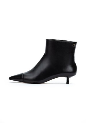 Bottine en cuir noir avec un bout pointu, un petit talon compensé et un design minimaliste. Présente un petit logo en accent à l'arrière.