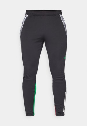 Pantalones deportivos negros con diseño ajustado, que presentan franjas blancas a lo largo de los lados y acentos verdes y rojos en los bordes inferiores. Textura suave.