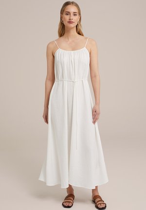 White maxi dress with adjustable spaghetti straps, gathered neckline, and a tied waist. Made from lightweight fabric with a soft texture.
