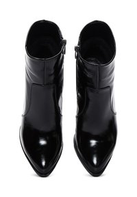Bottines en cuir noir avec une finition brillante, un bout pointu et une fermeture éclair sur le côté. Texture lisse avec un design minimaliste et sans quincaillerie visible.