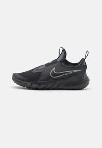 Czarny but sportowy z siateczkową cholewką, elastycznym paskiem i teksturowaną gumową podeszwą. Akcentowany srebrnym logo Nike oraz napisem "JUST DO IT".