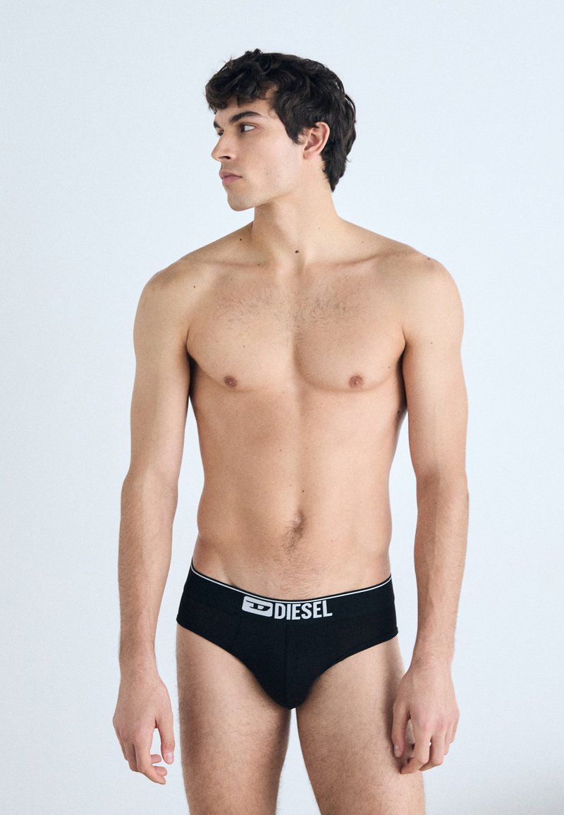 Zwarte katoenen boxer briefs met een witte "DIESEL" logo op de tailleband, aansluitend ontwerp, gladde textuur en minimalistische stijl.