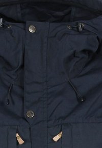 Giacca blu navy con cappuccio regolabile, due chiusure a pressione e dettagli in pelle beige vicino alle tasche. Tessuto liscio.