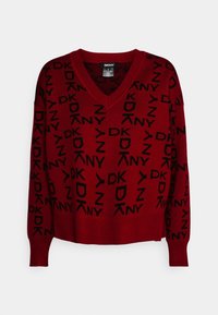 Roter Strickpullover mit V-Ausschnitt und langen Ärmeln. Schwarzes DKNY-Logo-Muster über den Stoff verteilt. Weicher Griff mit gerippten Bündchen.