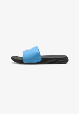 Blue slide sandal with a soft upper, textured black sole, and visible brand logo. Features a wide strap and a sleek, simple design.