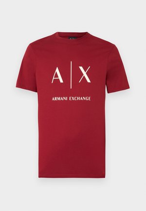 T-shirt rouge à manches courtes avec col rond, logo blanc "A | X" et texte "ARMANI EXCHANGE" centrés sur le devant.
