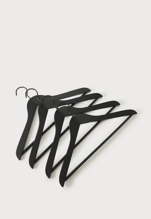 Quatre cintres en bois noirs avec crochets métalliques disposés en pile décalée sur fond blanc.