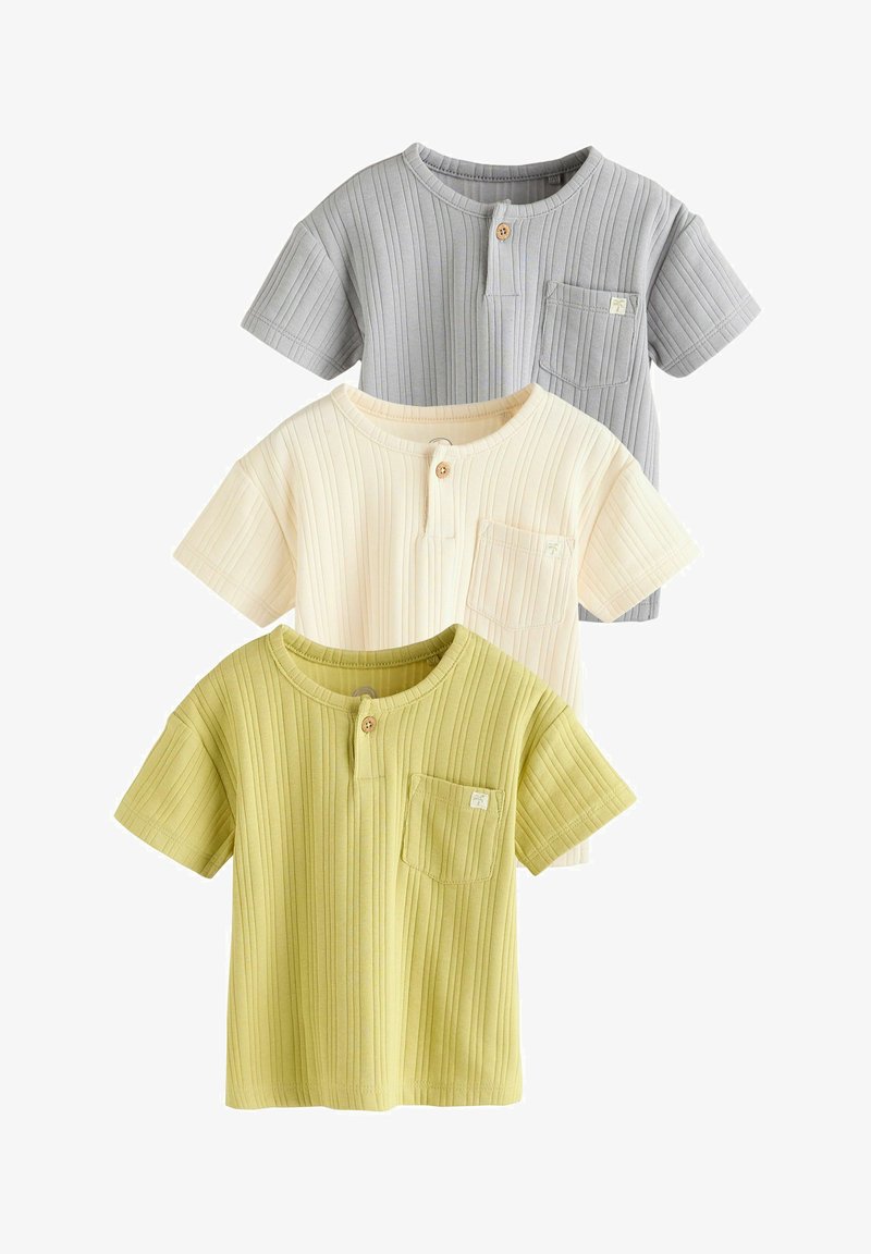 Trois chemises pour enfants à manches courtes côtelées en gris, crème et vert clair, chacune avec un petit bouton en bois et une poche poitrine sur fond blanc.