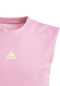 Ροζ χωρίς μανίκια τοπ από λεία ύφανση. Διαθέτει στρογγυλή λαιμόκοψη και κίτρινο λογότυπο Adidas στην επάνω αριστερή πλευρά.