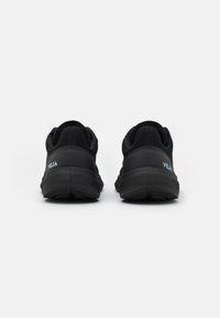 Baskets de sport noires avec une tige en mesh, semelle en caoutchouc, talon rembourré et logo "VEJA" en blanc sur le côté extérieur.