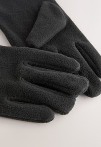 Egyszínű fekete polár kesztyű puha tapintással. Ötujjas, testhezálló kialakítás, melegség és kényelem biztosítására.