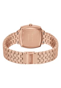 Montre en acier inoxydable rose doré avec un boîtier carré et un bracelet à maillons texturés. Présente des maillons à motifs et un fermoir portant le nom de la marque "Fossil."