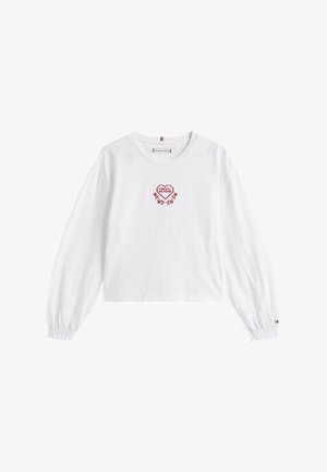 Crop top blanc à manches longues avec un col rond et des poignets élastiques. Présente un cœur rouge brodé et un motif floral sur la poitrine.