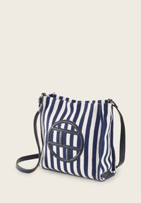 Borsa in tessuto a righe navy e bianche, con un accento circolare in pelle e una tracolla regolabile. Morbida al tatto, dimensioni medie.