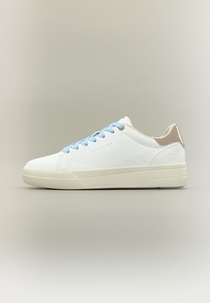 Baskets blanches basses avec lacets bleu clair et languette métallique beige au talon, sur un fond neutre.