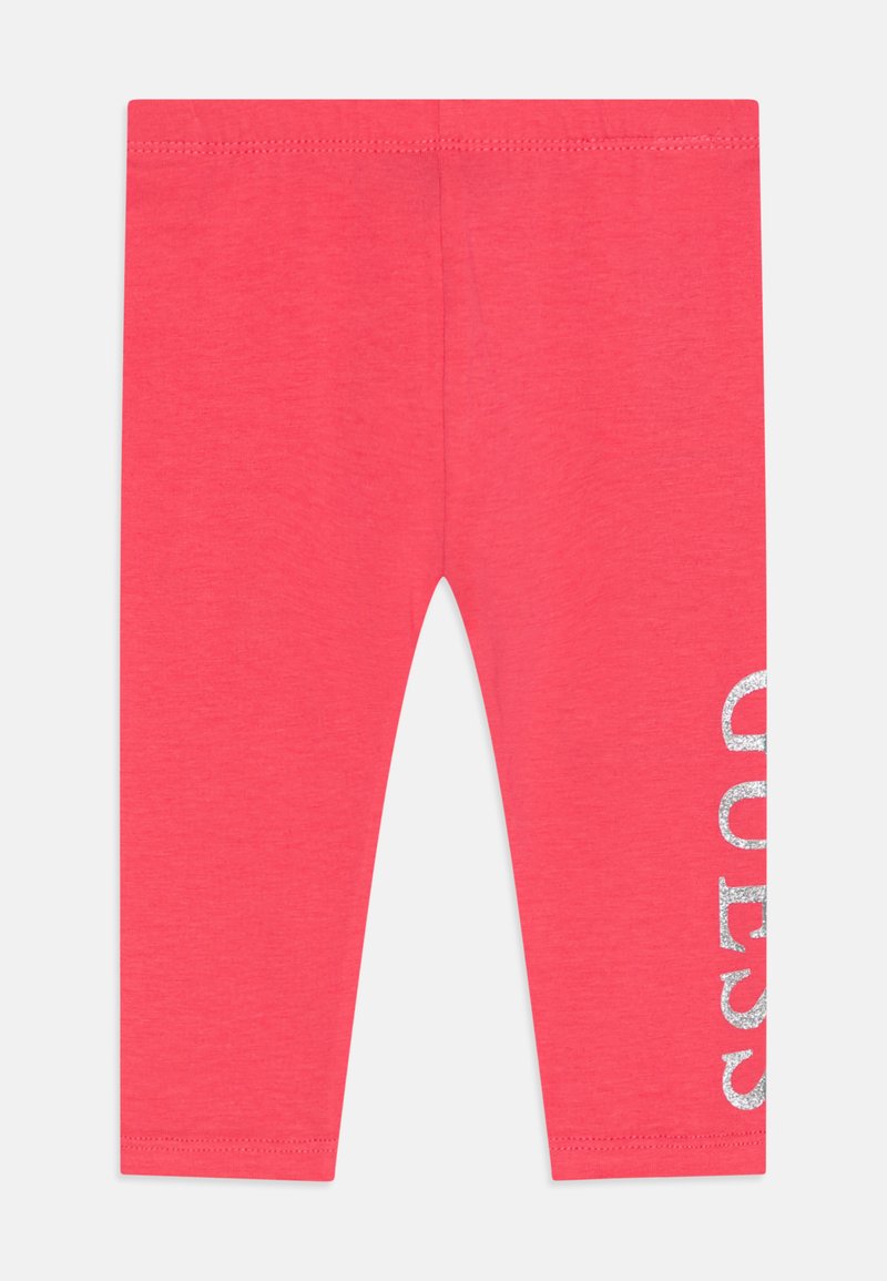 Koral leggings laget av myk bomull, med et skinnende sølv "GUESS" trykk på høyre ben og elastisk midje.