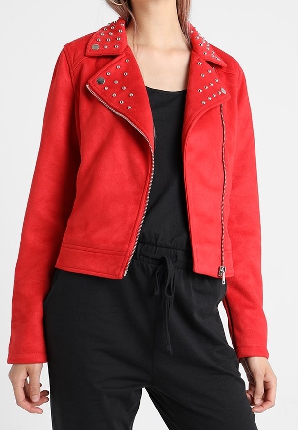 Veste de motard en suède synthétique rouge avec des clous en argent sur le col. Dispose d'une fermeture éclair et d'une silhouette ajustée avec une texture lisse.