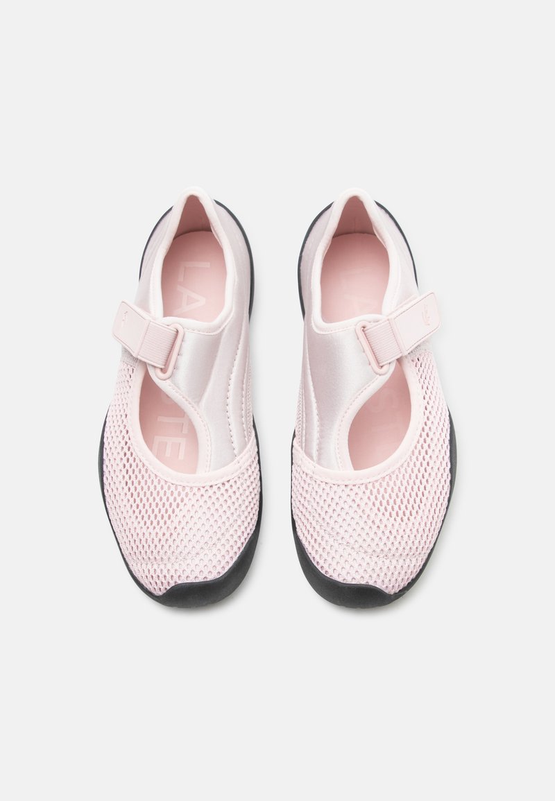 Scarpe rosa chiaro slip-on con punta in mesh, cinturino regolabile in velcro e suole nere, viste dall'alto su sfondo bianco.