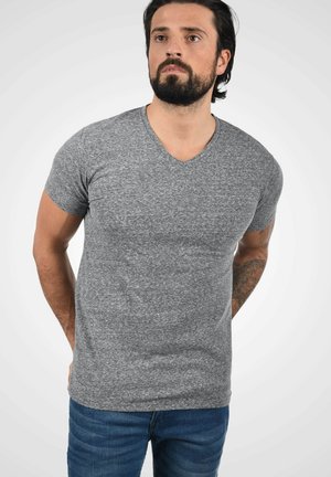 Grå v-hals t-shirt i en meleret struktur, korte ærmer og en tætsiddende design, parret med blå denim jeans.