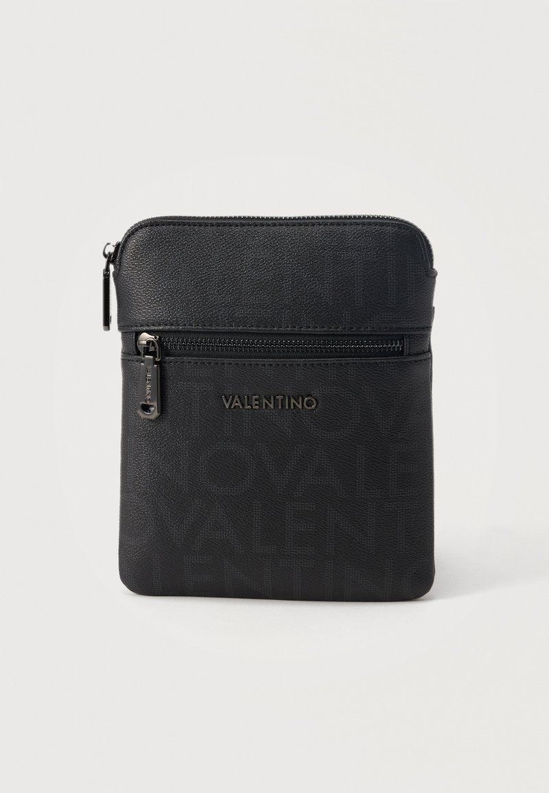 Μαύρη τσάντα Valentino τύπου crossbody με μπροστινή τσέπη με φερμουάρ, ανάγλυφο μοτίβο λογότυπου και ασημένιες λαβές φερμουάρ σε απλό λευκό φόντο.