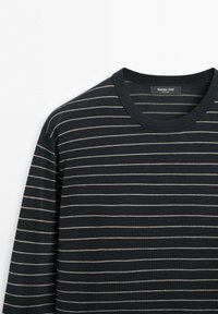 Donkerblauwe trui met lange mouwen, voorzien van dunne witte horizontale strepen en een ronde hals, platgevouwen op een witte achtergrond.