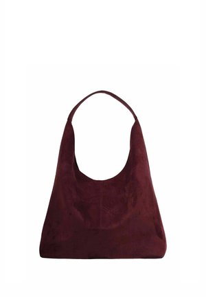 Dunkel burgunderrote Wildleder-Schultertasche mit einem breiten Riemen und weicher, lässiger dreieckiger Form vor weißem Hintergrund.