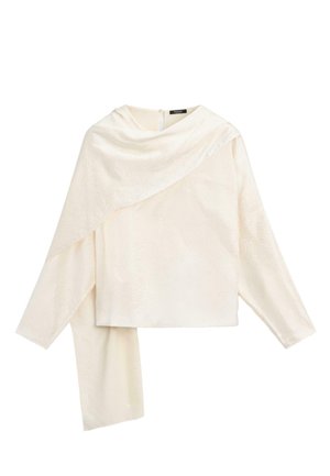 Cremefarvet bluse med lange ærmer og asymmetrisk draperet stofdetalje, der strækker sig fra halsudskæringen til kanten på den ene side.