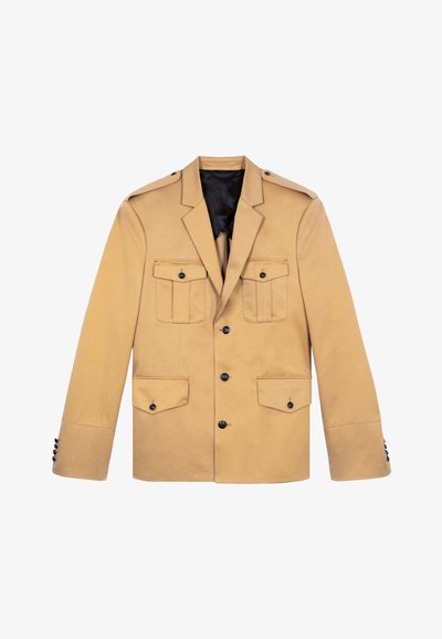 Blazer beige realizzato in un tessuto dalla consistenza liscia. Presenta quattro tasche frontali, bottoni neri e spalline. Fodera nera all'interno.