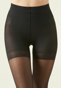 Medias negras con una parte superior texturizada y transpirable y una capa inferior lisa y transparente. Cuenta con una cinturilla amplia y cómoda.