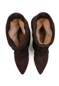 Stivali ankle in suede marrone con un design morbido, punta affusolata e una fodera liscia di un marrone chiaro. La texture esterna è morbida e opaca.