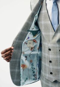 Grau karierter Sakkos mit floralem Futter in Hellblau. Verfügt über ein doppelt geknöpftes Design, Reverskragen und Knopfakzente.