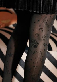 Collant neri trasparenti con vari motivi neri, tra cui stelle, cuori e motivi fantasiosi, con una texture liscia.