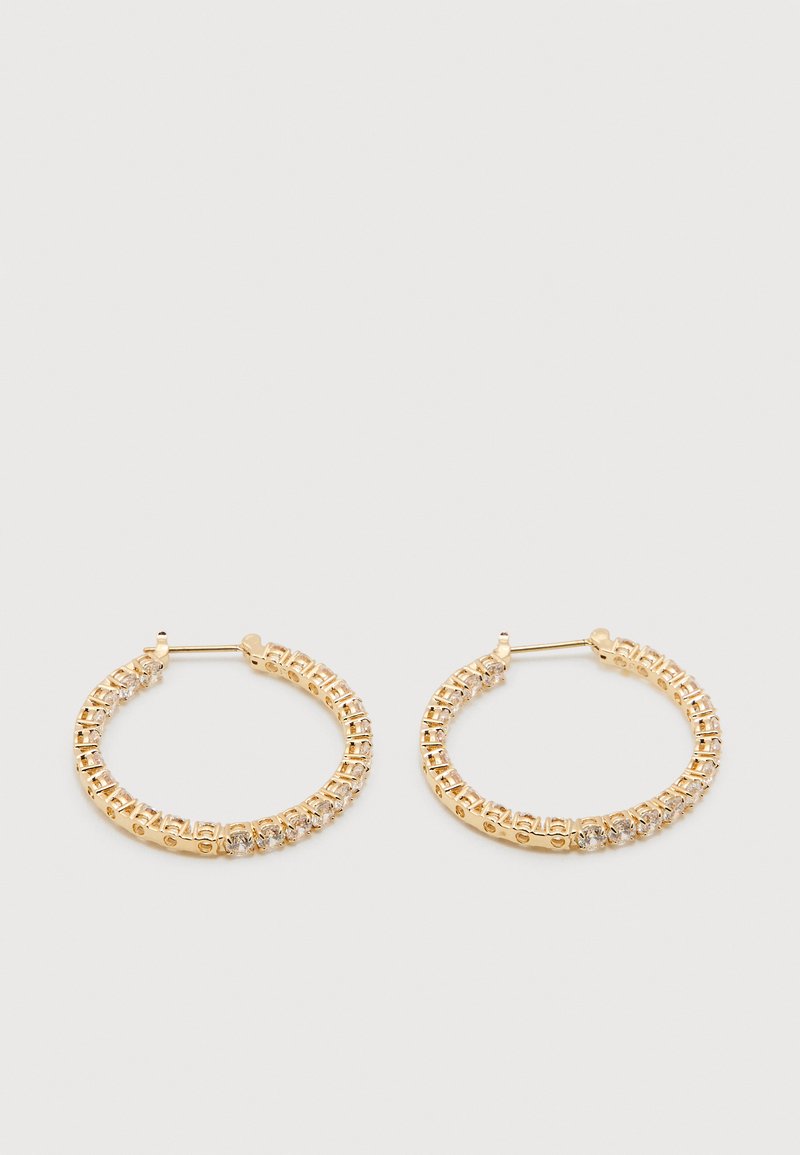 Pereche de cercei tip cerc din aur, împodobiți cu pietre prețioase rotunde clare, afișați pe un fundal alb simplu.