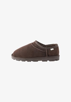 Pantofole marroni in camoscio senza lacci con morbida fodera in pelliccia e suola testurizzata, progettate per comfort e calore in ambienti interni.