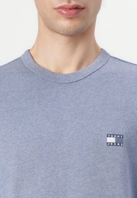 Μπλε βαμβακερή μπλούζα τύπου t-shirt με στρογγυλή λαιμόκοψη και μικρή ετικέτα λογότυπου σε ναυτικό και λευκό χρώμα στην αριστερή πλευρά του στήθους. Μαλακή υφή.