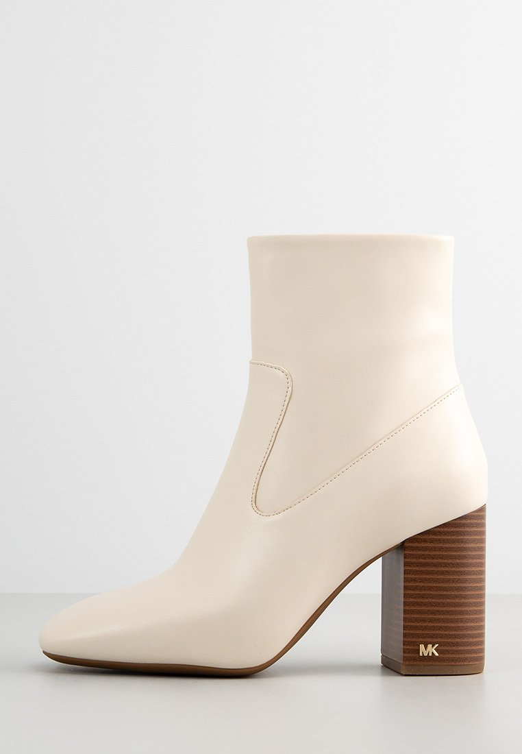 Stivale alla caviglia beige con tacco block in tonalità marrone texturizzato, punta affusolata, tomaia in pelle liscia e dettagli di cucitura sottili. Logo MK sul tacco.