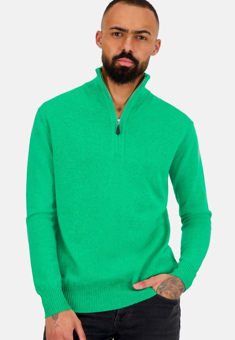 Grüne Zip-Up-Strickjacke aus gestricktem Stoff. Verfügt über einen hohen Kragen sowie Rippbündchen und -saum. Glatte Textur und moderne Passform.