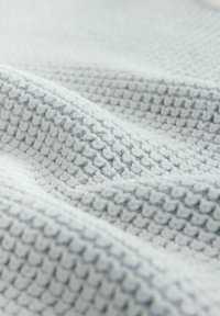 Material texturat de culoare albastră deschisă, cu un model ridicat, textură moale și un luciu subtil, prezentând multiple pliuri și ondulații pe tot parcursul său.