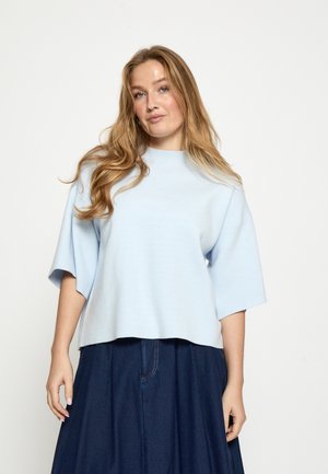 Pull bleu clair à manches courtes avec un col rond. Texture douce, coupe ample, associé à une jupe en jean foncé. Design simple sans motifs.