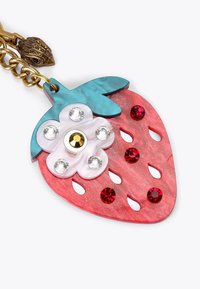 Ciondolo a forma di fragola in acrilico marmorizzato rosso, con foglie blu-verdi e cristalli decorativi. Presenta ritagli e un accento floreale. Collana in oro.