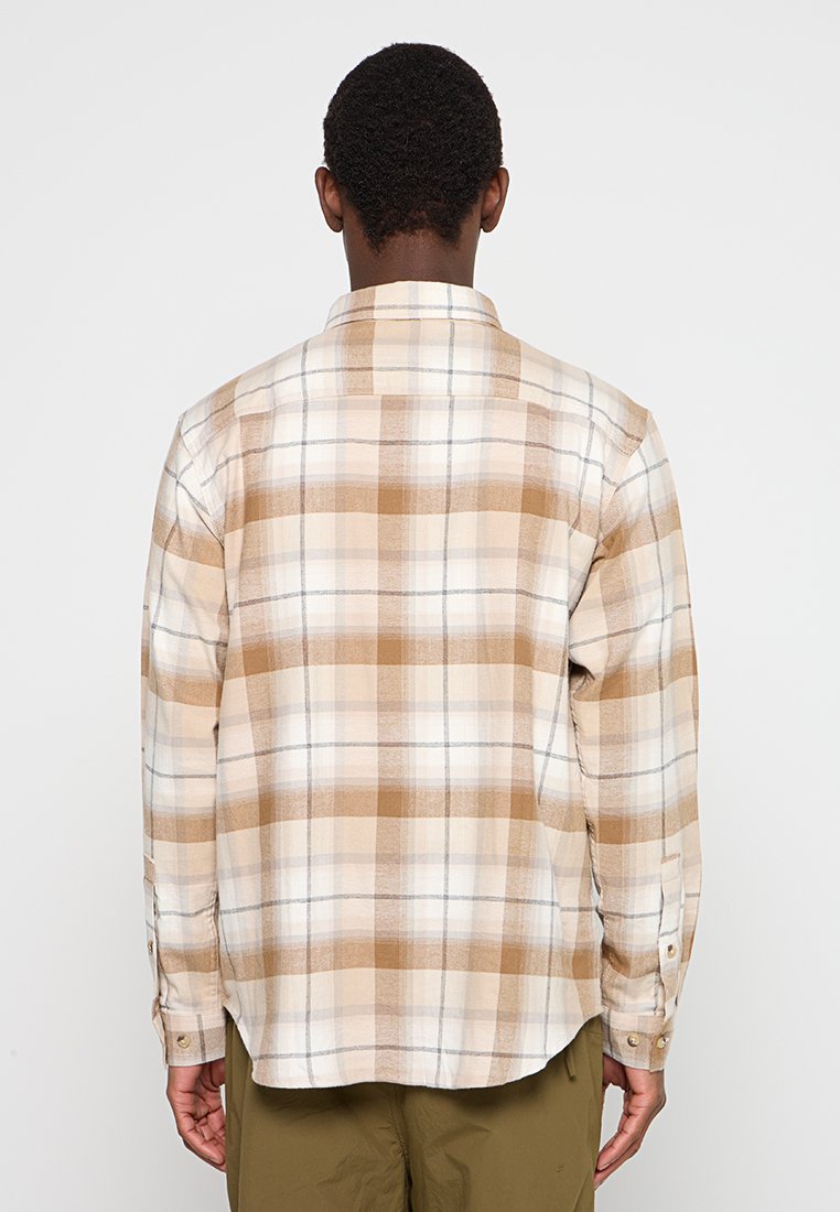 Camisa de cuadros abotonada en beige, marrón y crema, con un corte relajado, mangas largas y cuello estándar; presenta un patrón de cuadros cuadrados.