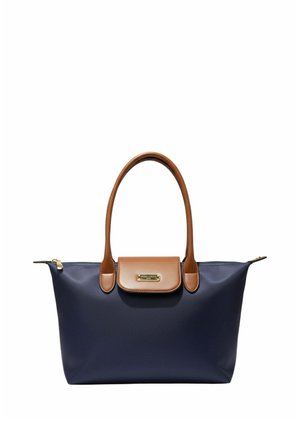 Sac cabas bleu marine avec anses en cuir marron et rabat, fermeture éclair dorée et petite plaque de marque dorée sur le rabat.