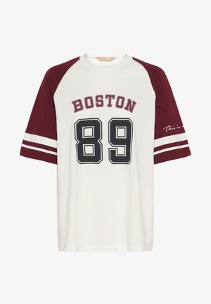 Burgundia ja valge pesapallistiilis t-särk, mille esiküljel on trükitud "BOSTON" ja "89", eristuvate varrukate ja varrukatel olevate triipudega.