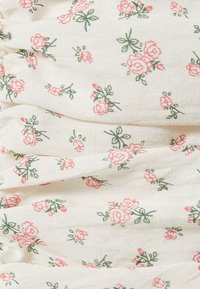 Tela blanca con una superficie texturizada que presenta un patrón de pequeñas rosas rosas y hojas verdes, dispuestas en un diseño repetitivo.