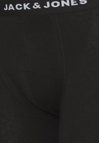 Schwarze Boxershorts mit breitem elastischen Bund, der "JACK & JONES" in weißem Text trägt. Glatte Stoffqualität und taillierte Passform.