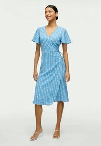 Blaues Wickelkleid mit kurzen Ärmeln, das ein vertikales Streifenmuster in Weiß aufweist. Knielang und aus leichtem Stoff gefertigt.