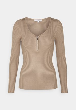 Beige ribbet langærmet top med dyb V-hals og lynlås foran. Stoffet har en blød tekstur og tætsiddende design.